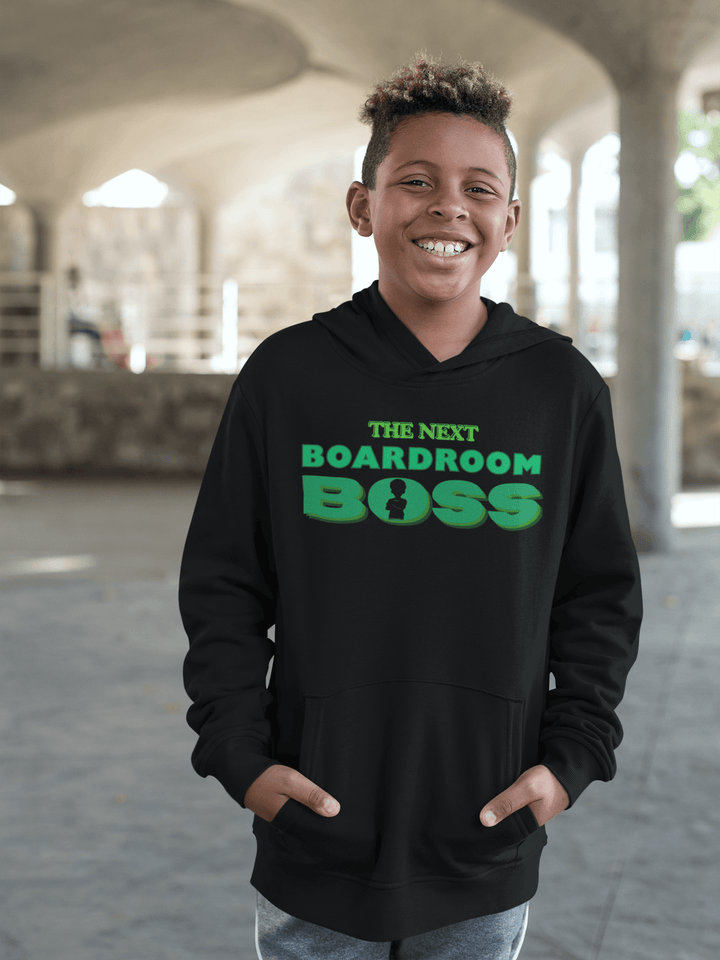 Young Black boy wearing The Next Boardroom Boss Hoodie from TL Johnson’s Mini Monarchs Apparel; motivational fashion for future leaders. Featuring green typography