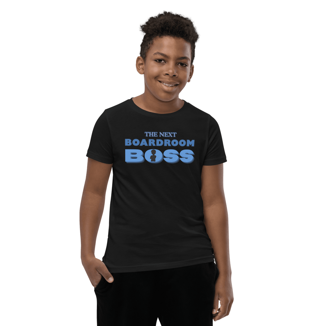 Young Black boy smiling in Black and Blue The Next Boardroom Boss T-shirt from TL Johnson’s Mini Monarchs line; empowerment apparel for future leaders.