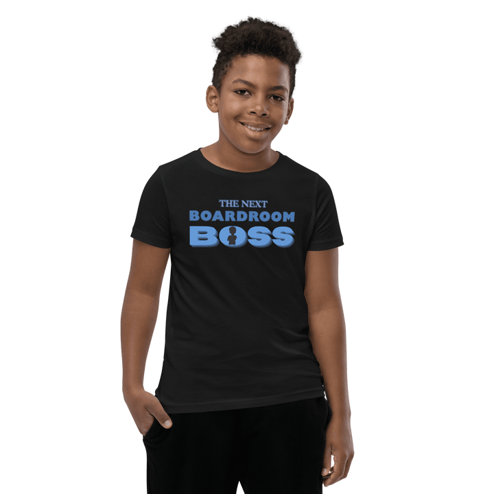 Young Black boy smiling in Black and Blue The Next Boardroom Boss T-shirt from TL Johnson’s Mini Monarchs line; empowerment apparel for future leaders.