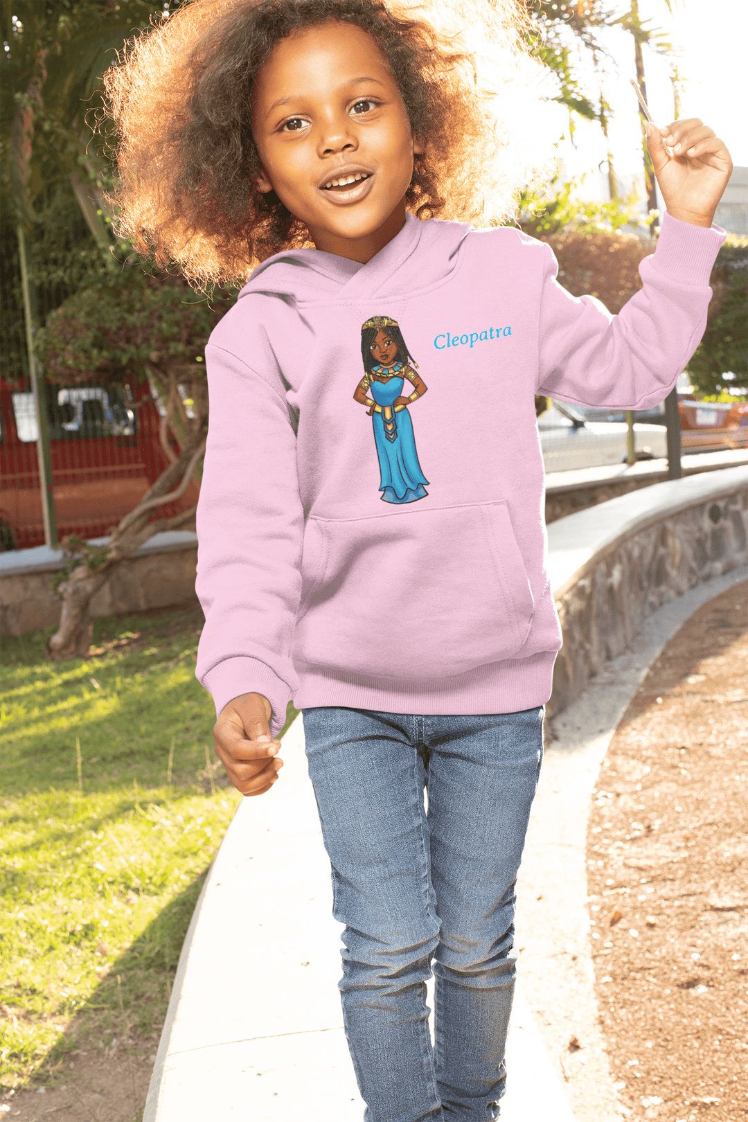 Young girl wearing Pink Cleopatra hoodie representing African heritage hoodie celebrating intelligence and grace with gold crown design.