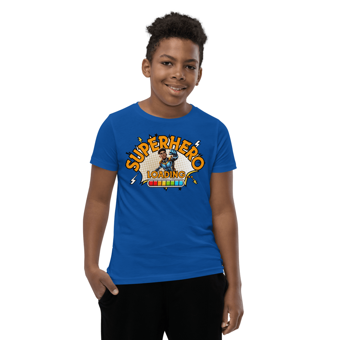 Young Black boy smiling while wearing Blue Superhero Loading T-shirt from TL Johnson’s Dream Big collection; motivational apparel celebrating growth and imagination