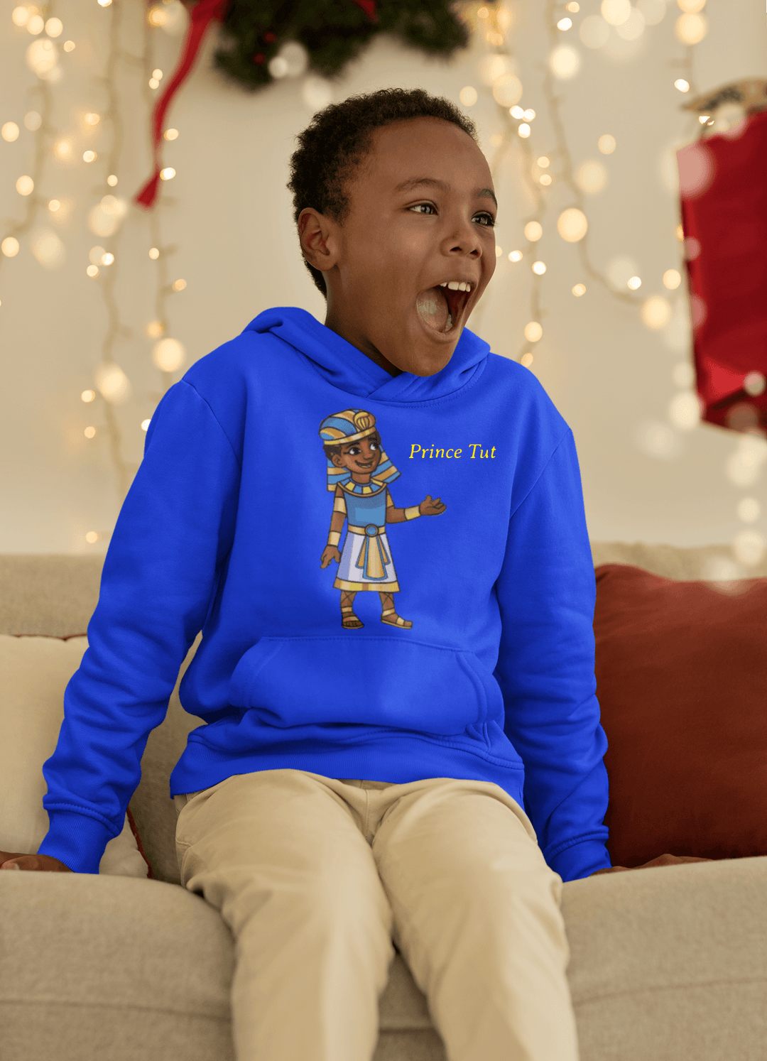 Black boy wearing Blue Tut “Lead With Wisdom” hoodie inspired by TL Johnson’s Mini Monarchs Universe; African royalty design symbolizing wisdom and leadership.