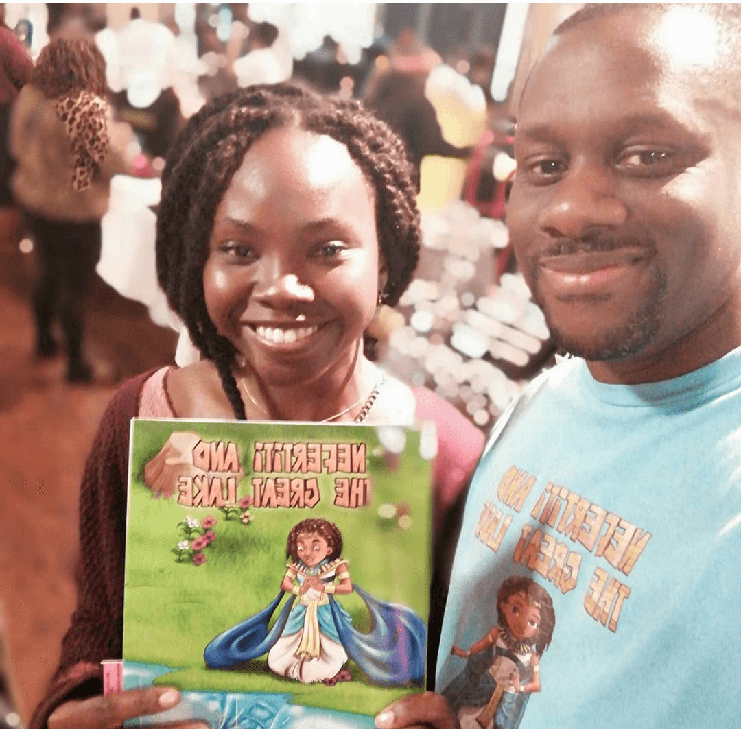 Smiling woman holding Nefertiti & The Great Lake standing next to author (Mini Monarchs 1.)